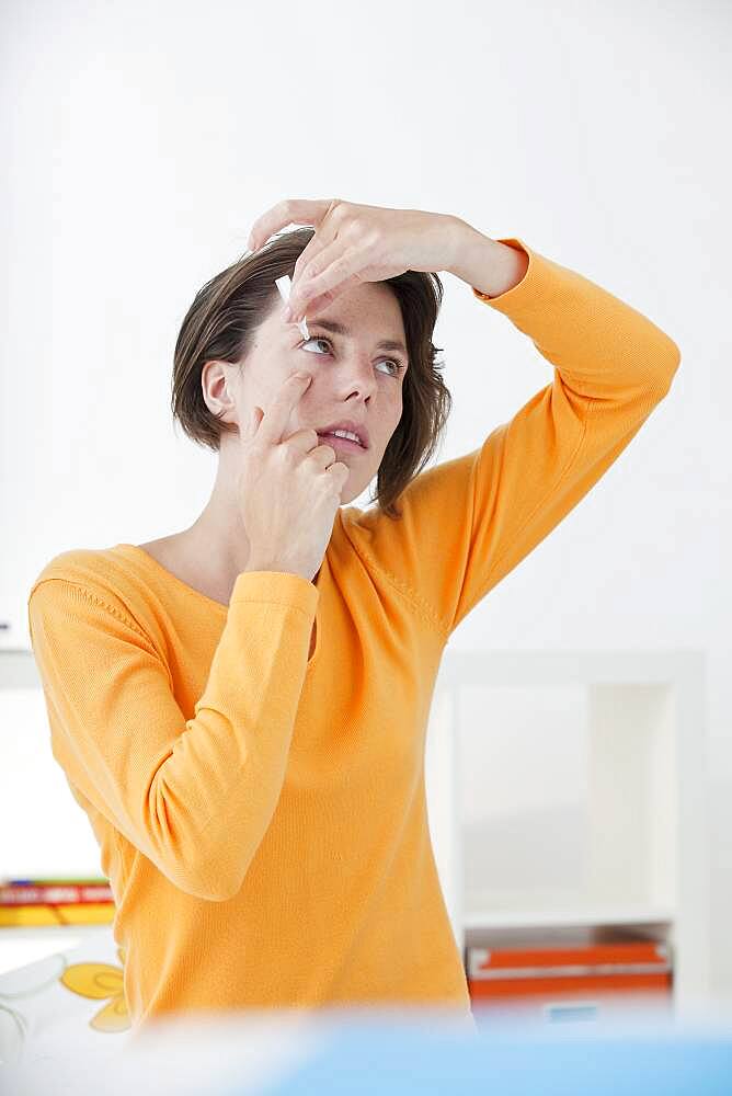 Woman using eye lotion