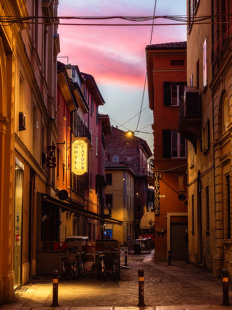 An alley in Bologna at sunrise, with pink clouds in the sky, Bologna, Emilia Romagna, Italy, Europe