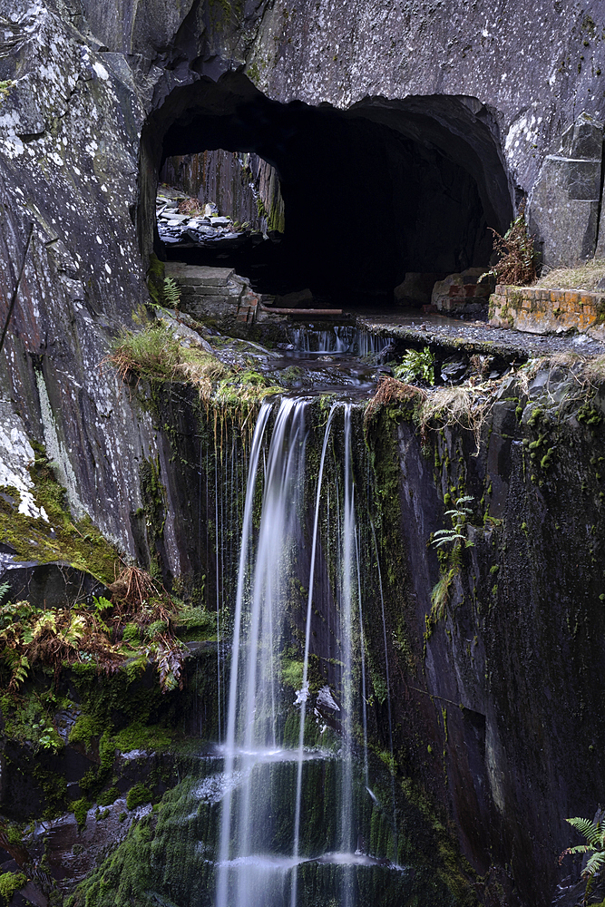 Waterfall falling from a Slate Cavern Tunnel Entrance, Dinorwig Quarry also known as Dinorwic Quarry, Eryri or Snowdonia National Park, North Wales, UK