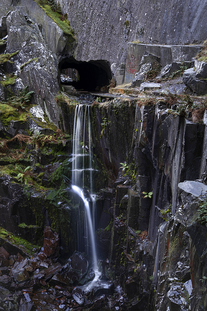 Waterfall falling from a Slate Cavern Tunnel Entrance, Dinorwig Quarry also known as Dinorwic Quarry, Eryri or Snowdonia National Park, North Wales, UK