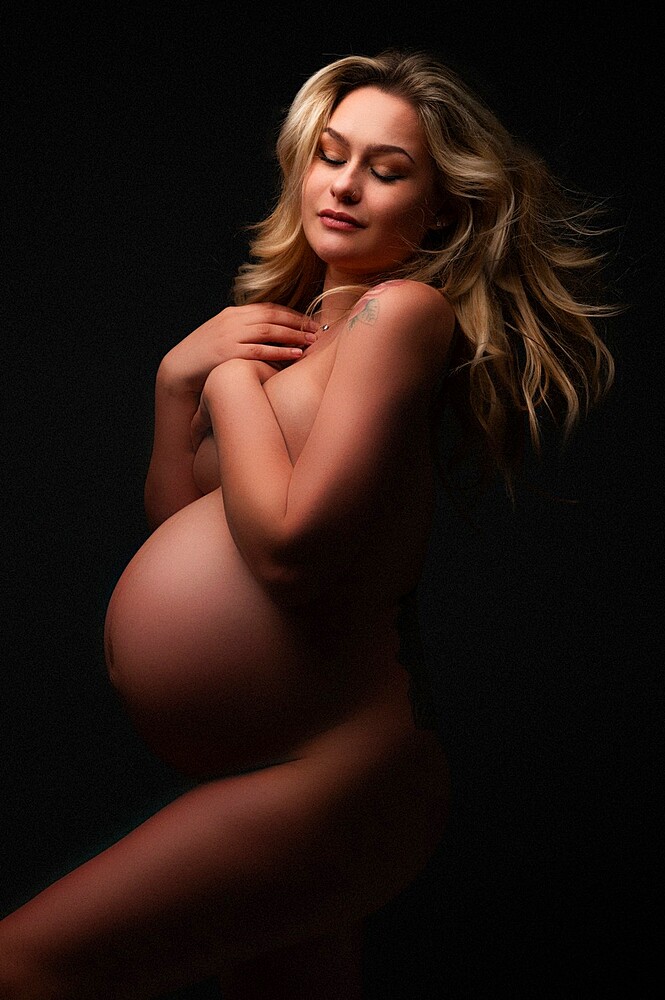 Artistic shot of a pregnant woman in a studio, United Kingdom, Europe