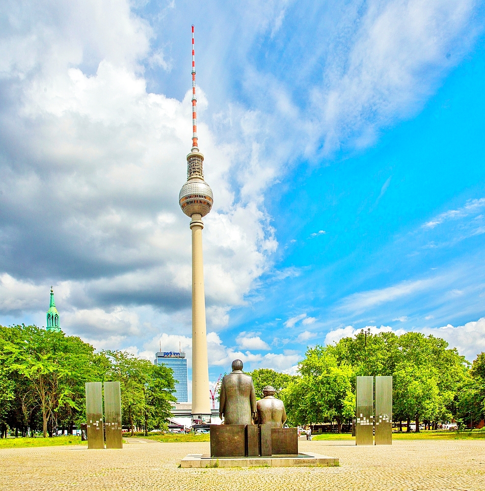 Marx and Engels statues survey the Berlin TV tower (Fernsehturm) in Marx-Engels Forum, a public park in the Mitte district, central Berlin, Germany, Europe