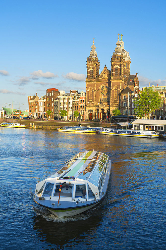 Tourist boat and Basilica of Saint Nicholas, Amsterdam, The Netherlands, Europe