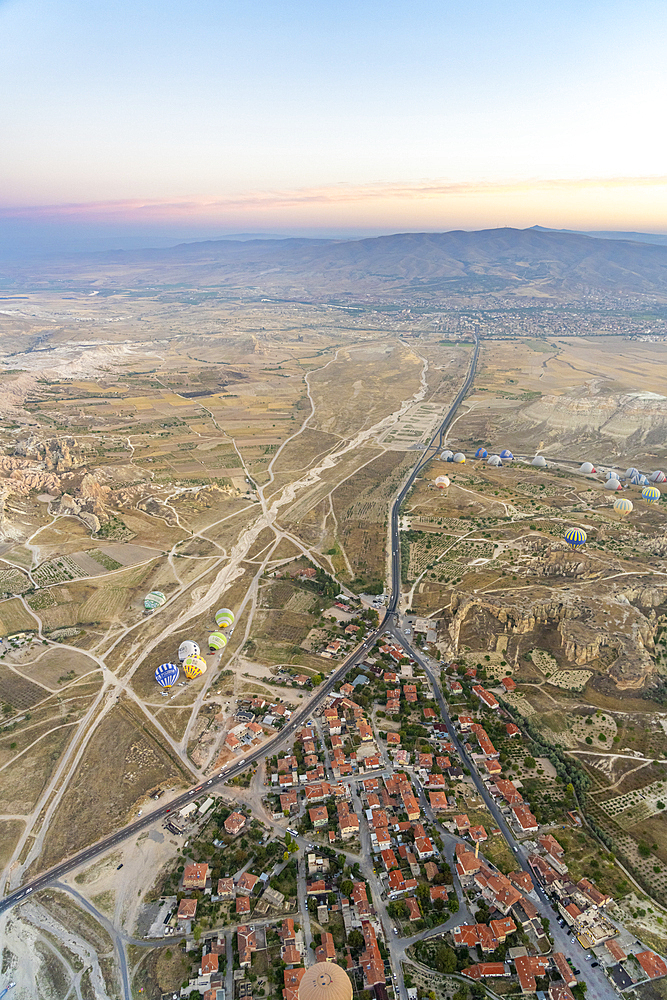 Aerial view of Cavusin and hot air balloons at dawn, Avanos District, Nevsehir Province, Cappadocia, Central Anatolia Region, Anatolia, Turkey, Asia Minor, Asia