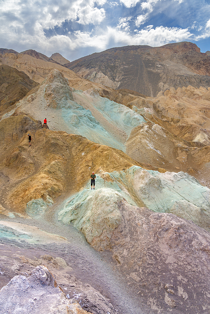 Tourists exploring colorful rocks at Artist's Palette, Death Valley National Park, Eastern California, California, USA