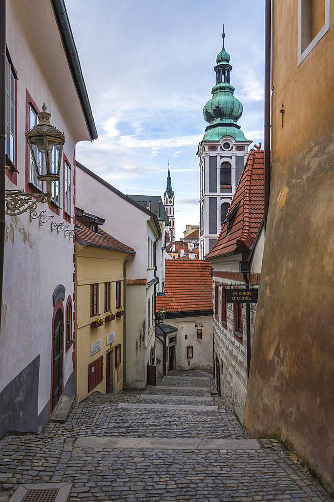 Narrow alley with view of towers of St. Jost Church and Church of St. Vitus in background, UNESCO World Heritage Site, Cesky Krumlov, Czech Republic (Czechia), Europe