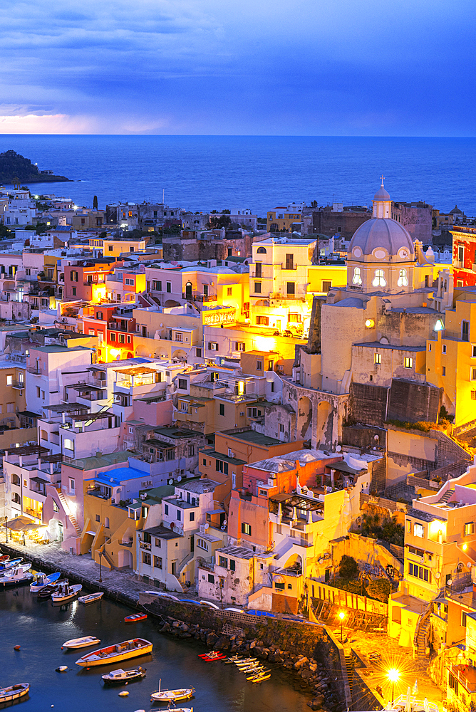 Illuminated fishing village of Marina Corricella at dusk, Procida island, Tyrrhenian Sea, Naples district, Naples Bay, Campania region, Italy, Europe