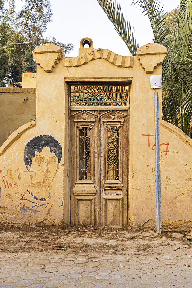 Faiyum, Egypt. February 19, 2022. Wooden door in a wall in the village of Faiyum.