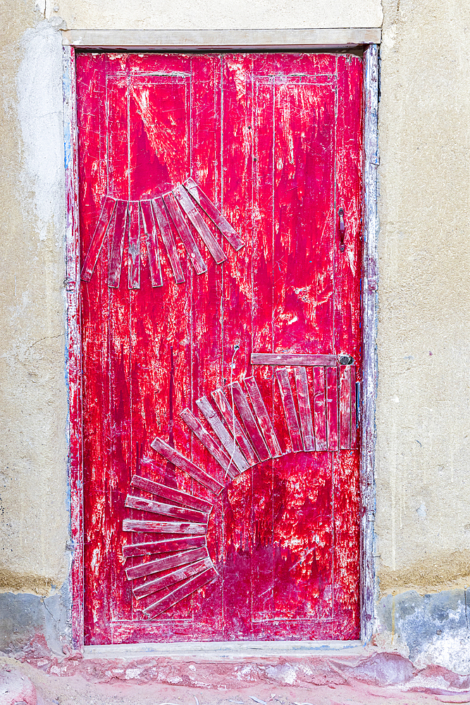 Faiyum, Egypt. February 19, 2022. A red painted door on a building in the village of Faiyum.