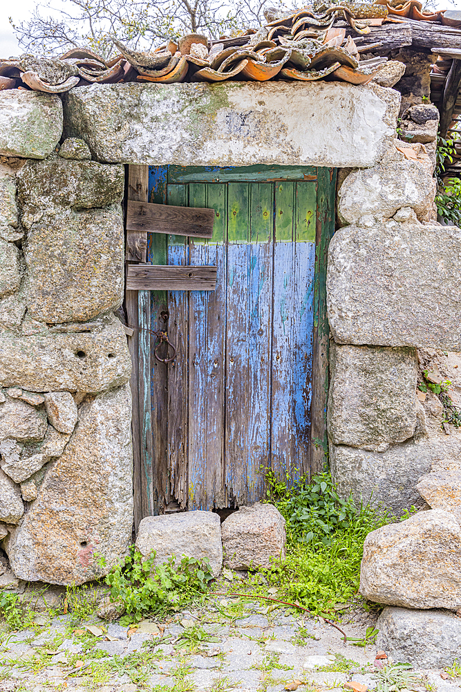 Europe, Portugal, Monsanto. An old blue wooden door in a stone wall.