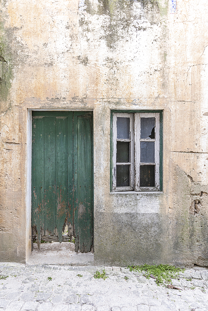 Europe, Portugal, Monsanto. An old green wooden door in a stucco house.