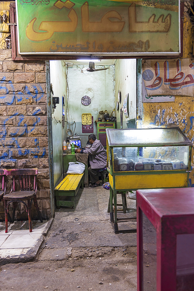 Luxor, Egypt. February 23, 2022. Shopkeeper watching TV in Luxor.