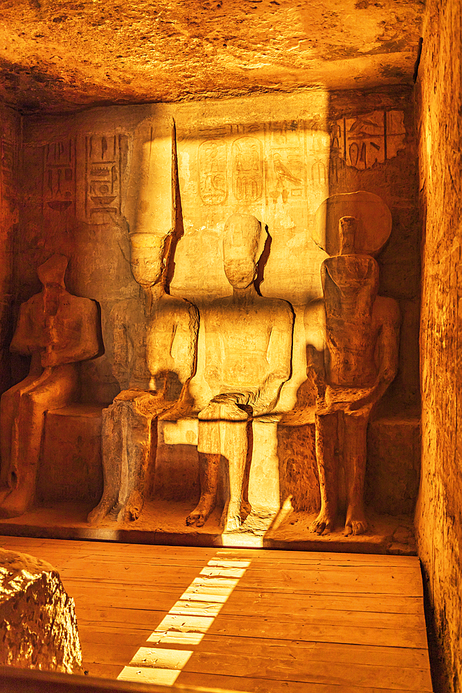 Abu Simbel, Aswan, Egypt. February 23, 2022. Sunrise light on statues of Ptah, Amun, Ramesses II, and Ra in the Holiest of Holies in the Great Temple of Ramesses II.