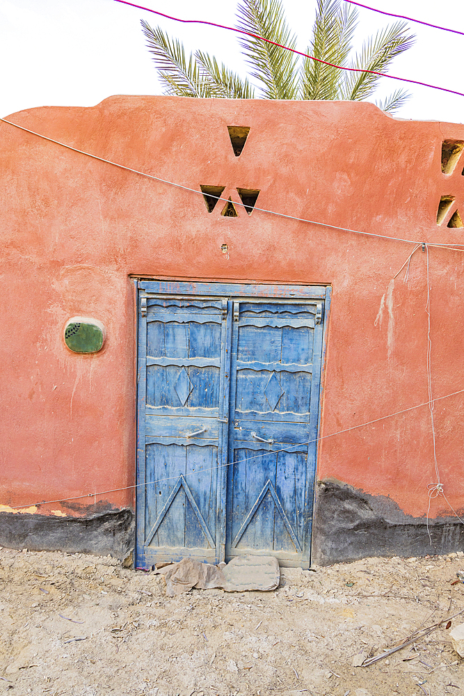 Faiyum, Egypt. Blue painted doors in a wall in the village of Faiyum.