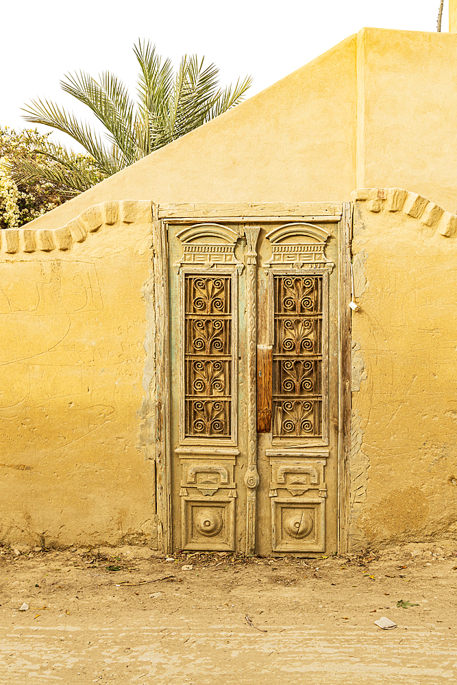 Faiyum, Egypt. Wooden door in a wall in the village of Faiyum.