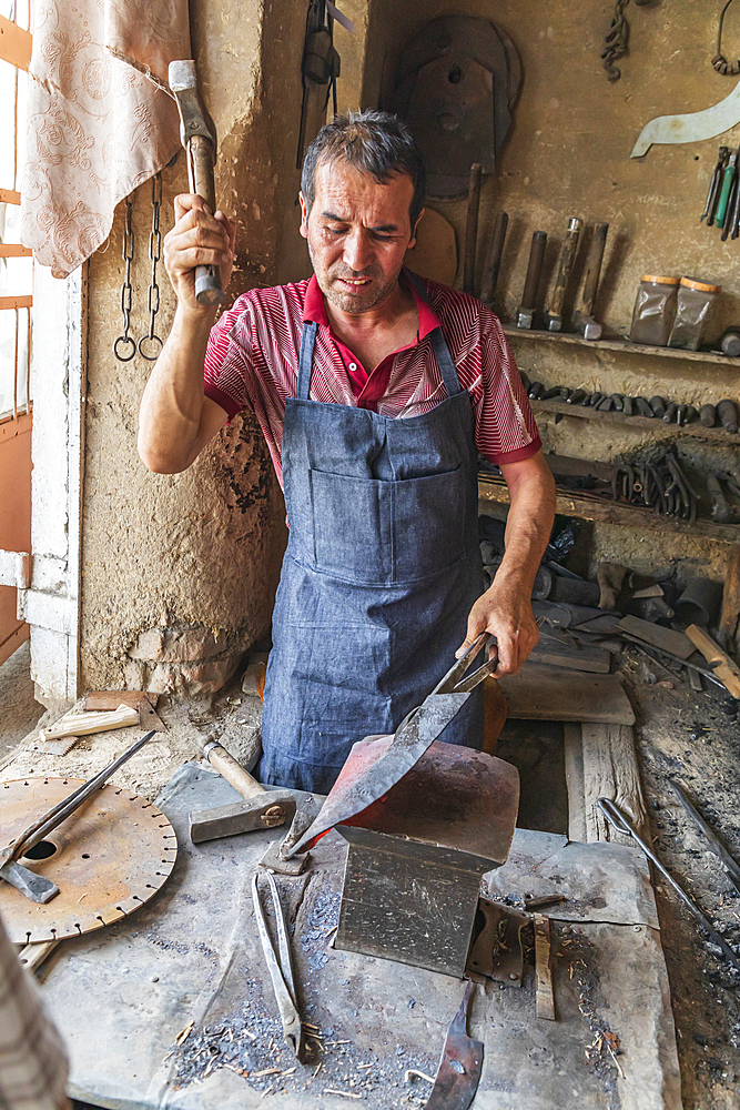 Istaravshan, Sughd Province, Tajikistan. August 19, 2021. Blacksmith hammering hot metal in Istaravshan. Editorial Use Only