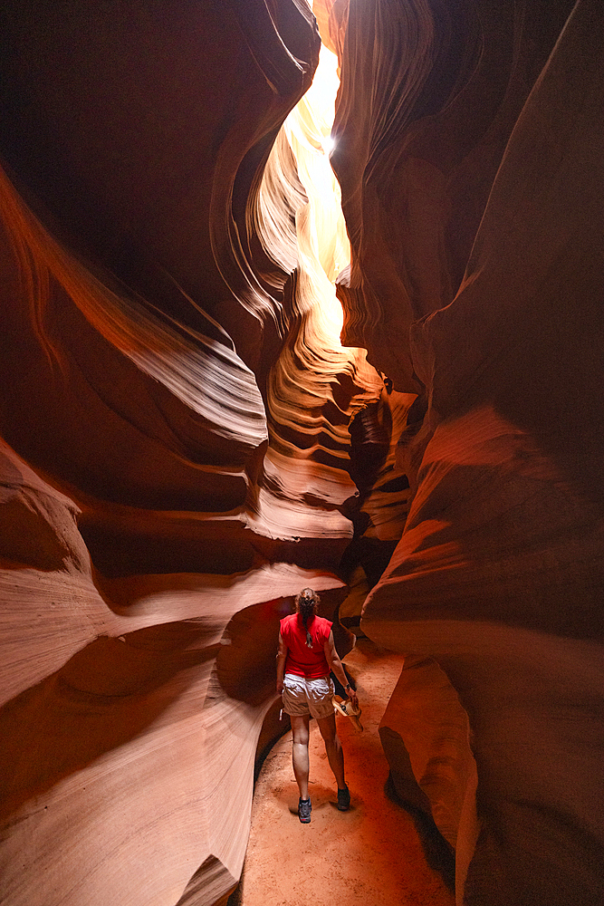 A girl enjoys the beautiful view of the Upper Antelope Canyon on a sunny summer day, Page, Arizona, United States of America, North America