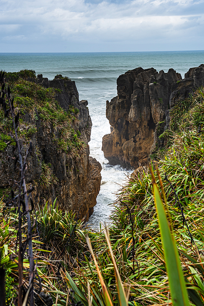 Vertical View of Towering Limestone Cliffs and Deep Ocean Channel at Punakaiki, West Coast, New Zealand