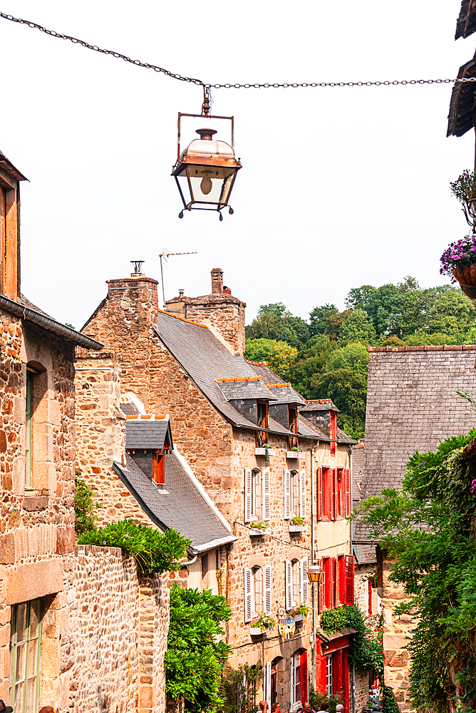 Narrow cobbled street with stone houses and lanterns in medieval town of Dinan Brittany France