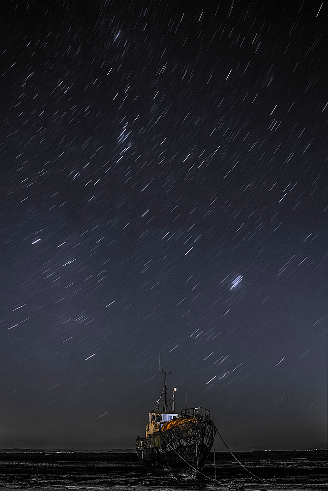 Star trails above the derelict trawler Vita Nova, from the Cumbrian Coast, Furness Peninsula, Cumbria, England, United Kingdom, Europe