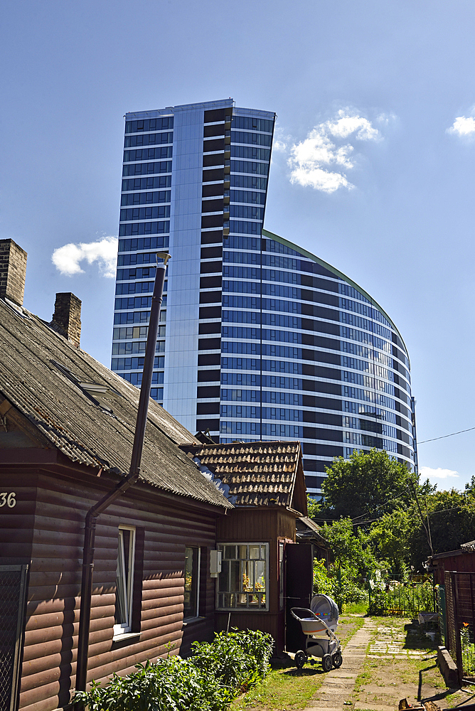 Old wooden houses surrounded by modern office towers in the Snipiskes district, Vilnius, Lithuania, Europe