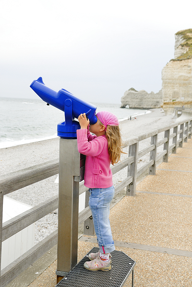 Little girl looking through a telescope, Etretat, Cote d'Albatre, Pays de Caux, Seine-Maritime department, Upper Normandy region, France, Europe