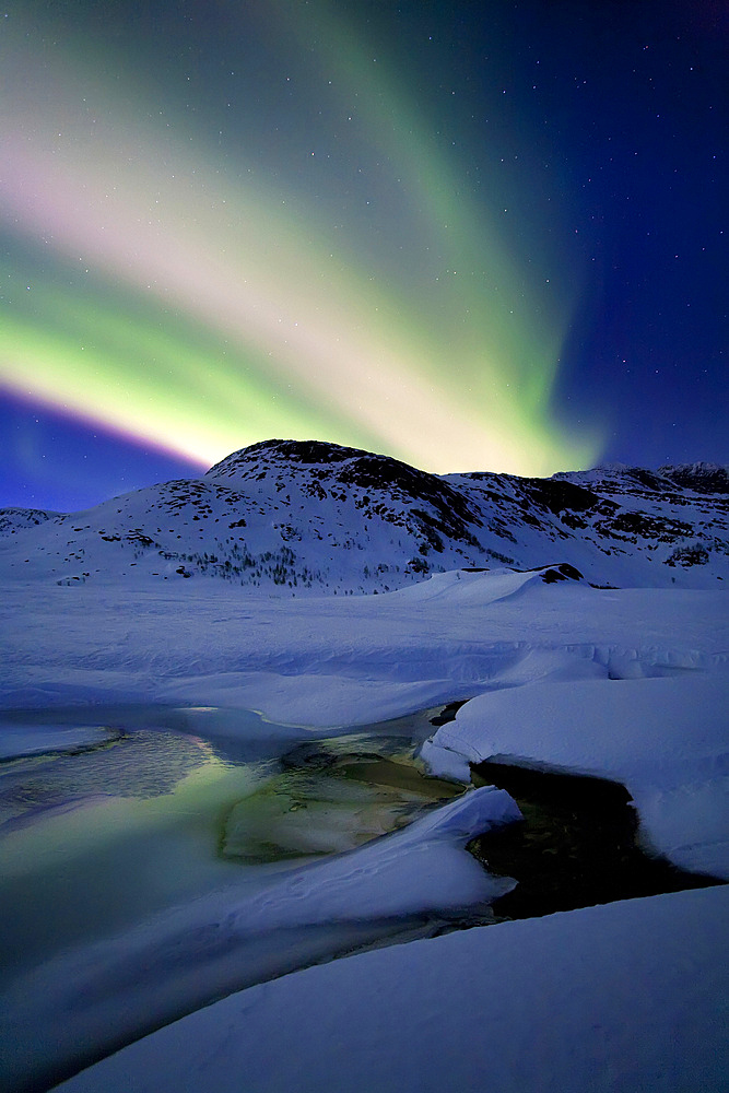Aurora Borealis over Mikkelfjellet Mountain in Troms County, Norway. Auroras are the result of the emissions of photons in the Earth's upper atmosphere.