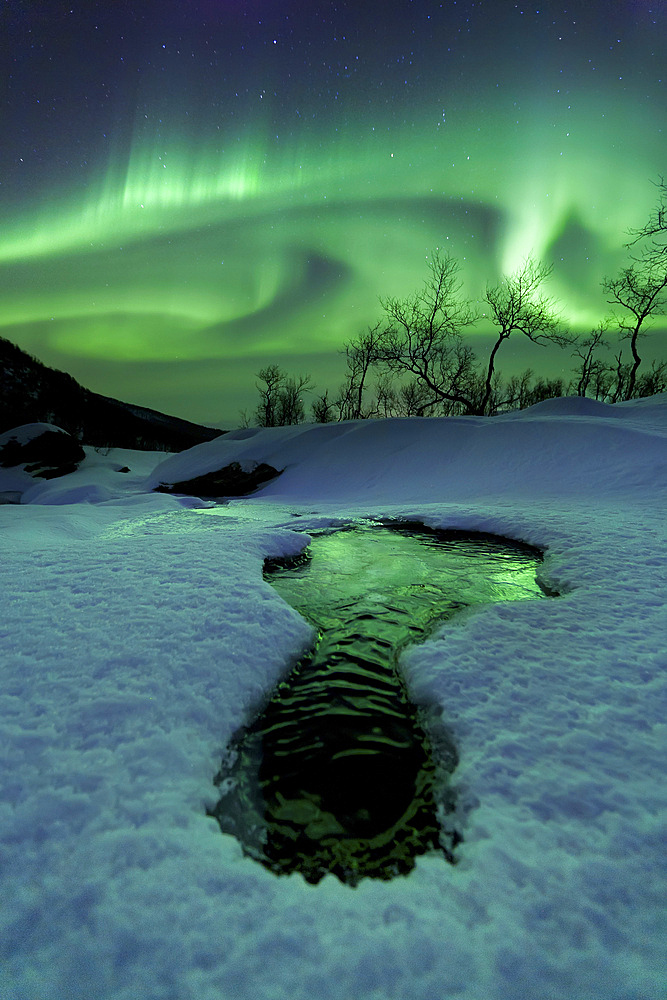 Aurora Borealis over a frozen river, Klubbfjellet Mountain, Nordland, Norway.