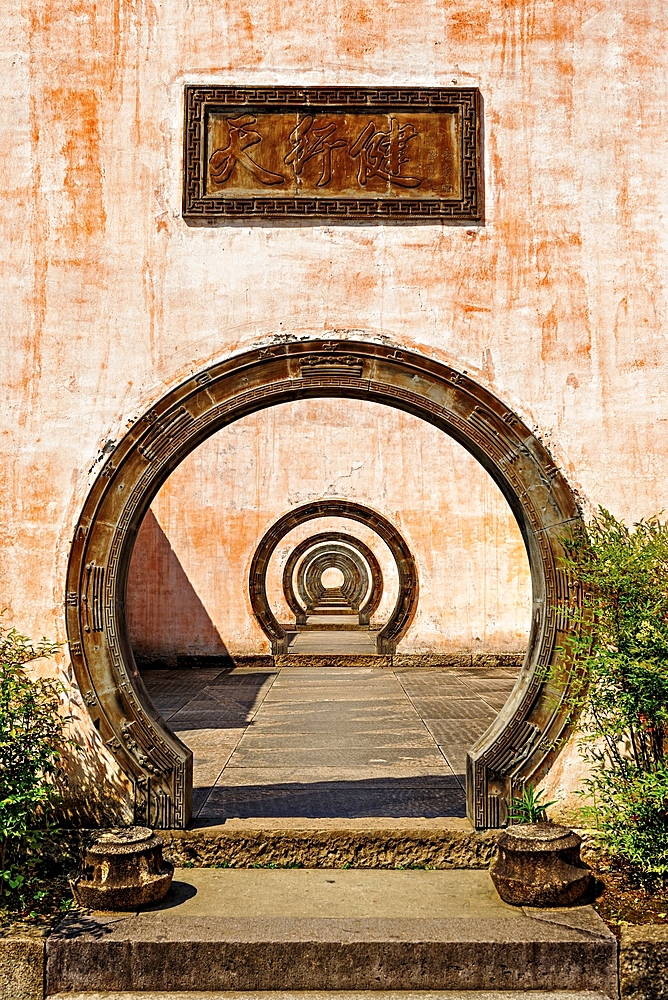 A series of outdoor circular doorways, Chengkan Ancient Village. The village was established 1800 years ago by the Luo family clan. It has buildings dating as early as the Song Dynasty (960 to 1279 AD). Huangshan City, Anhui, China.