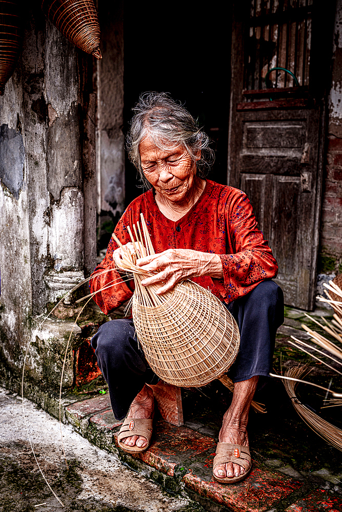 Woman weaving handmade bamboo fish traps, Hanoi, Vietnam. (MR)