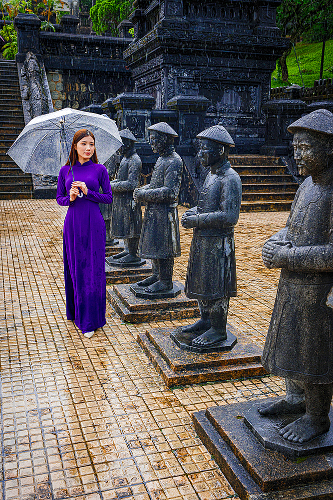 Woman in traditional ao dai looking at statues, Khai Dinh Mausoleum, Hue, Vietnam. (MR)