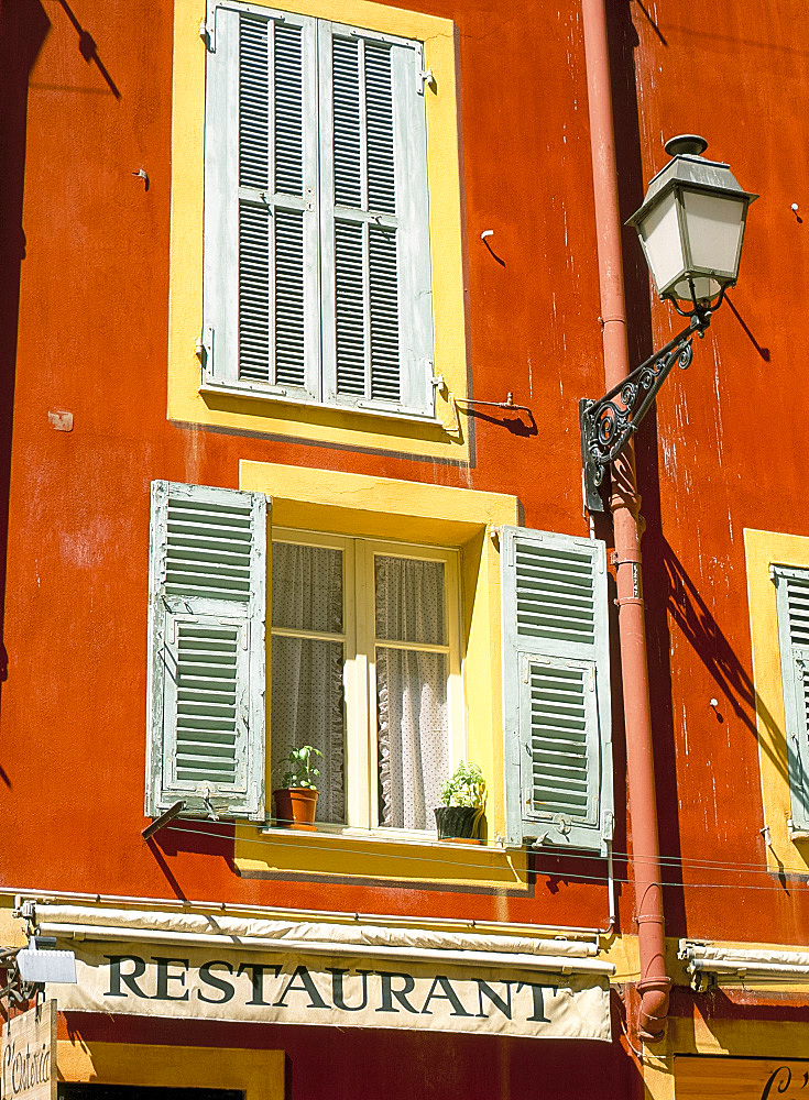 Architectural detail of lamp and shuttered windows above a restaurant awning, Old Town, Nice, Alpes Maritimes, Provence, French Riviera, France, Europe