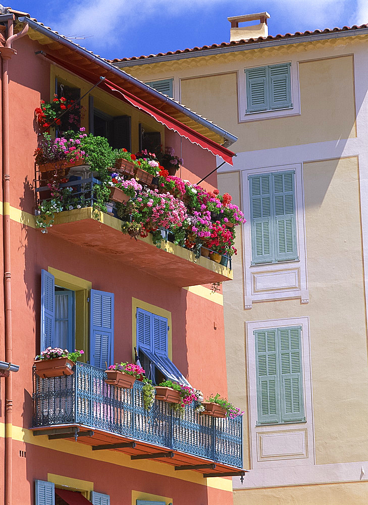 Balconies with blue wrought iron and shutters, with pots of geraniums in the town of Villefranche on the Cote d'Azur, Provence, France, Europe