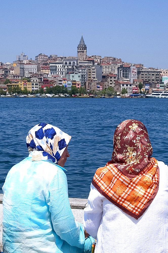 Two women in headscarves sitting in front of the Golden Horn, Istanbul, Turkey, Europe