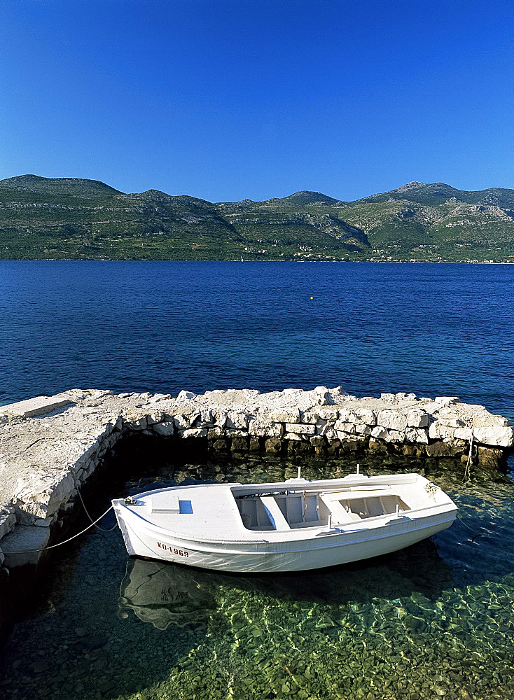 A small boat in clear seas off the island of Korcula, Dalmatia, Croatia, Europe