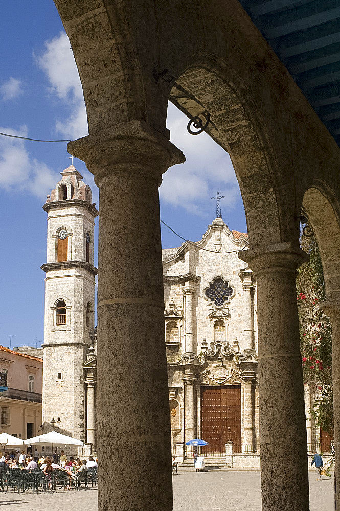 Catedral de San Cristobal and a cafe viewed through the arches of an arcade in the Plaza de la Catedral, Habana Vieja (old town), Havana, Cuba, West Indies, Central America