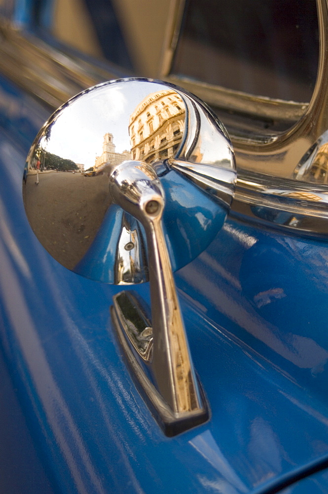 A shiny mirror on a vintage American car reflecting old buildings, Havana, Cuba, West Indies, Caribbean, Central America