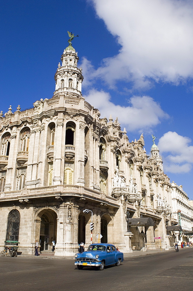 A vintage 1950's American car passing the Gran Teatro de Habana in central Havana, Cuba, West Indies, Central America