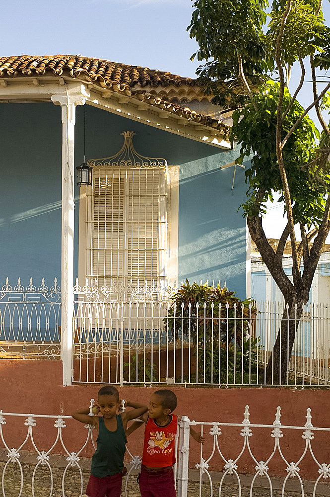 Two boys in front of the Museo de Arquitectura Colonial in a restored house, Casa Sanchez Iznaga, Trinidad, Cuba, West Indies, Central America