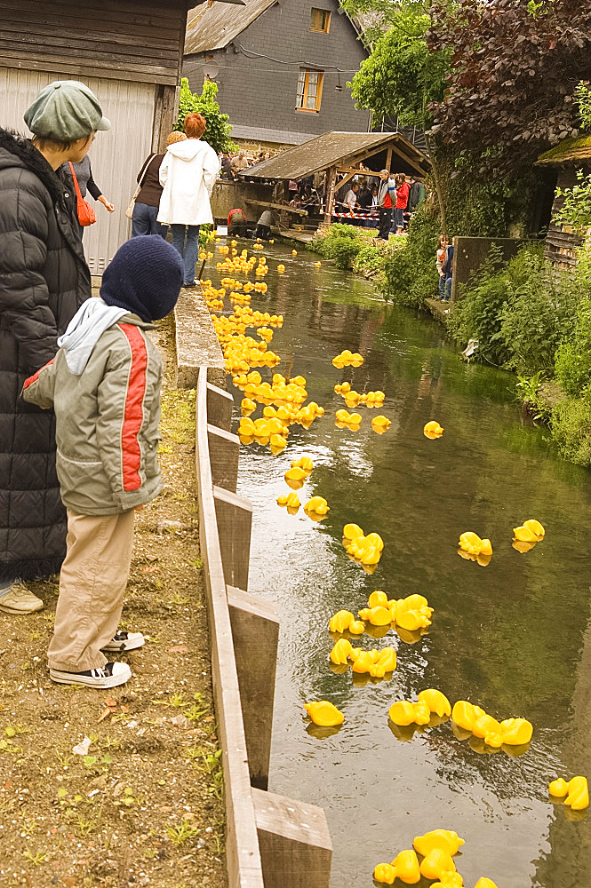 People watching the traditional rubber duck race along a stream in Cormeilles, Normandy, France, Europe