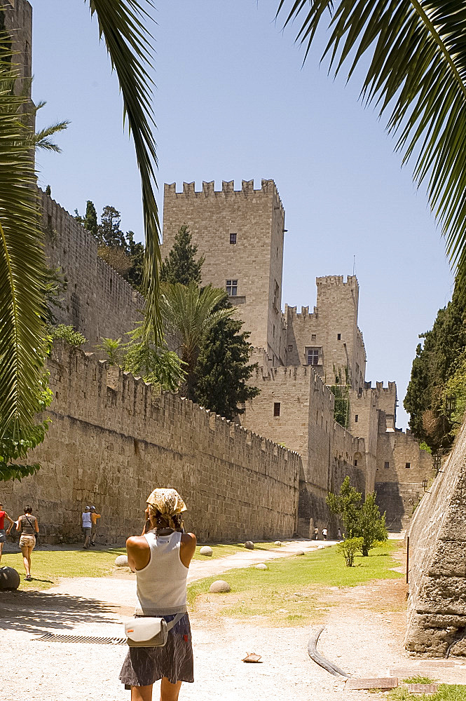 Tourists in the dry moat surrounding the city walls and fortress in Rhodes Town, Rhodes, Dodecanese, Greek Islands, Greece, Europe