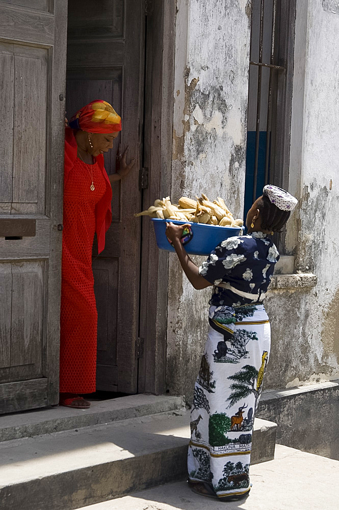 A woman selling corn door to door on a street in Stone Town, Zanzibar, Tanzania, East Africa, Africa