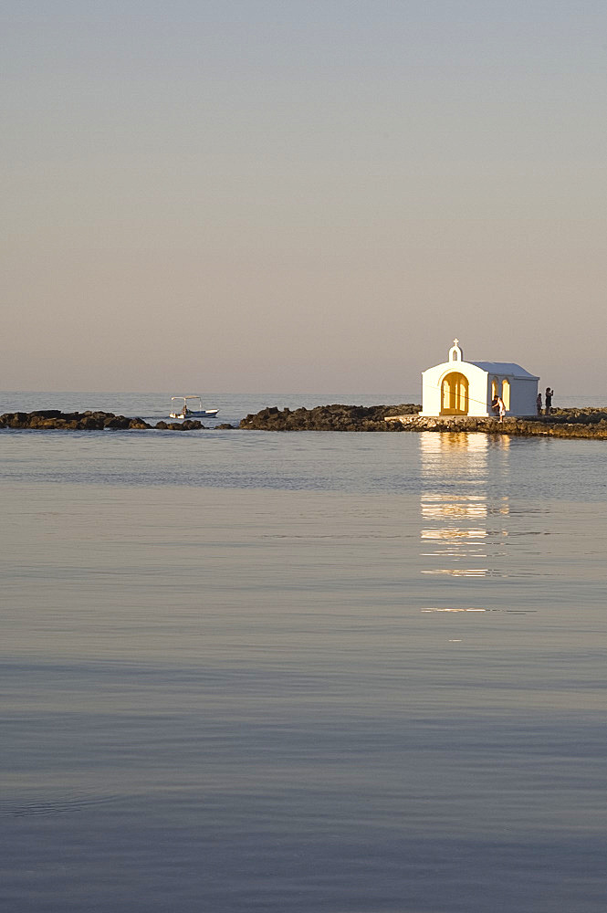 A small white washed church at the end of a quay in the village Yeoryioupolis near Hania on the north coast of Crete, Greece, Europe