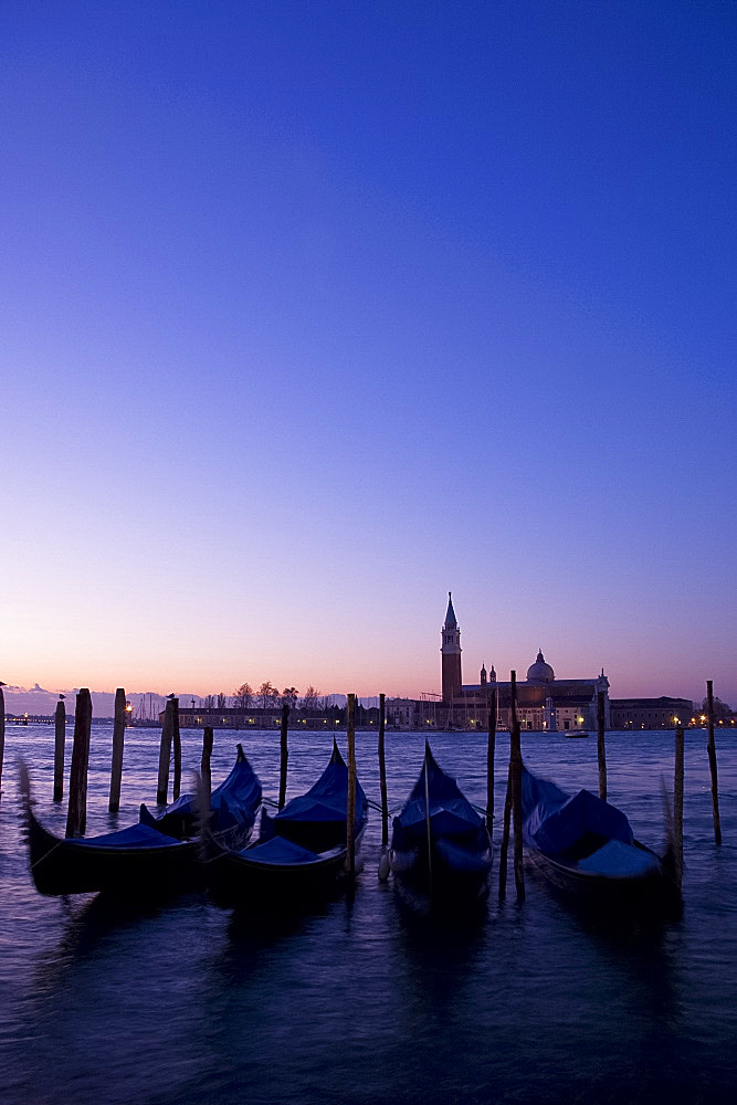 Gondolas at sunrise and San Giorgio Maggiore in silhouette in the background, Venice, UNESCO World Heritage Site, Veneto, Italy, Europe