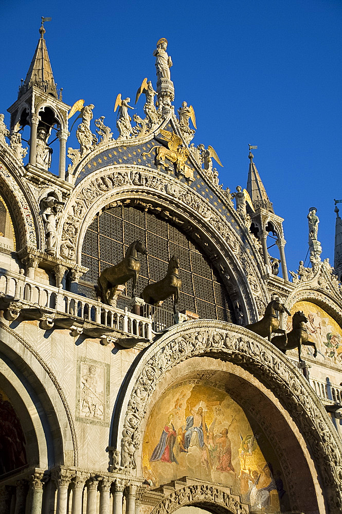 A close-up of the facade of the Basilica San Marco in St. Mark's Square showing statues called the Horses of St. Mark, Venice, UNESCO World Heritage Site, Veneto, Italy, Europe