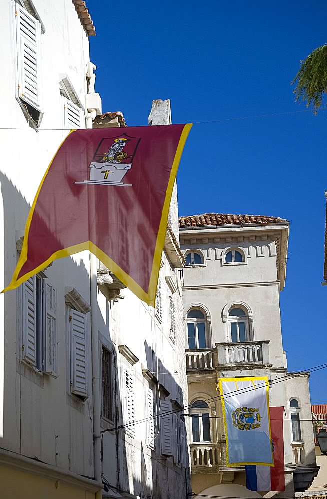 Medieval flags and stone paving in the main shopping street, Srednja Street, Rab Town, island of Rab, Kvarner Region, Croatia, Europe