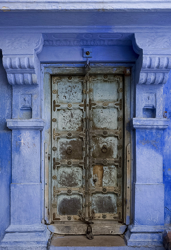 An old metal door of a traditional blue painted house in Jodhpur, Rajasthan, India, Asia