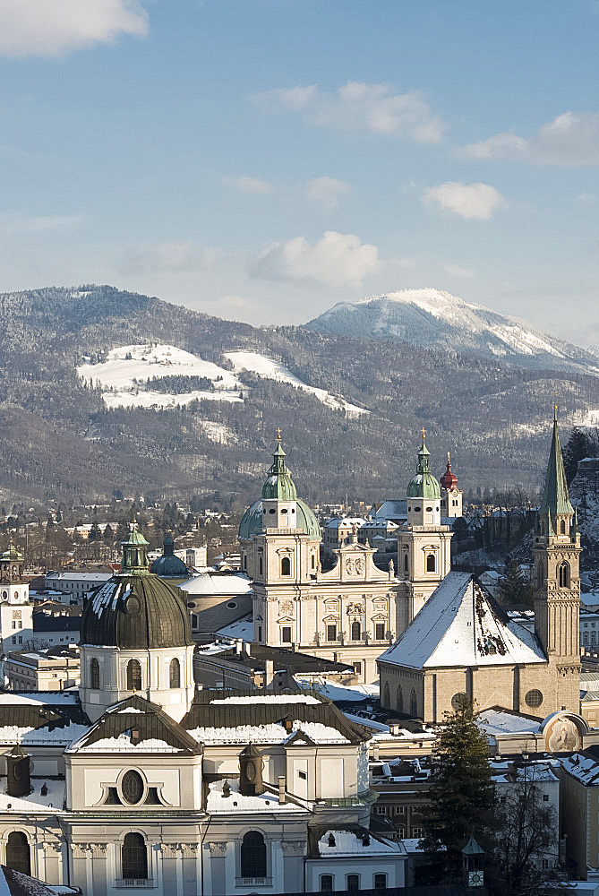 The domes of the Salzburg Cathedral and Franziskaner Kirche in the Altstadt and distant snow covered mountains, Salzburg, Austria, Europe