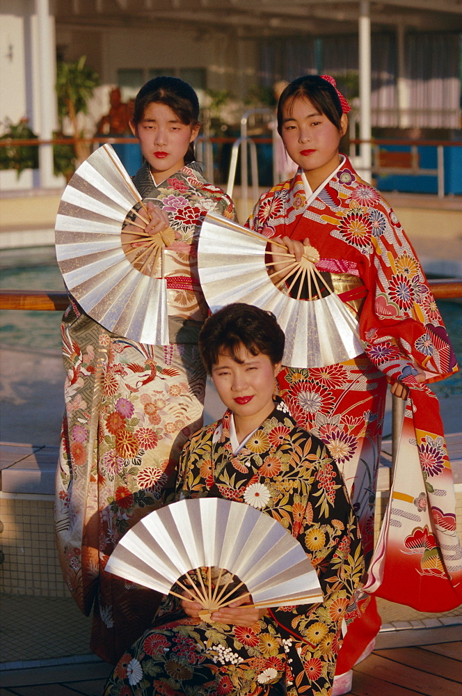 Portrait of three young women in traditional kimonos holding fans, Tokyo, Japan, Asia