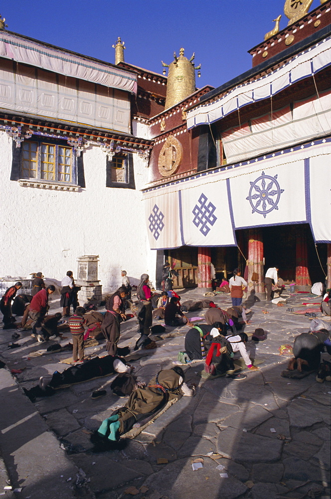 Pilgrims prostrating outside the Jokhang Temple, Lhasa, Tibet, China, Asia